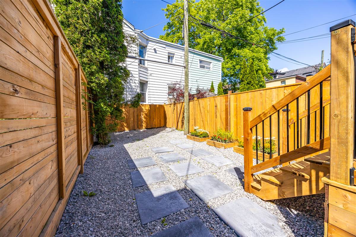 Landscaped backyard with stone pavers and cedar fence